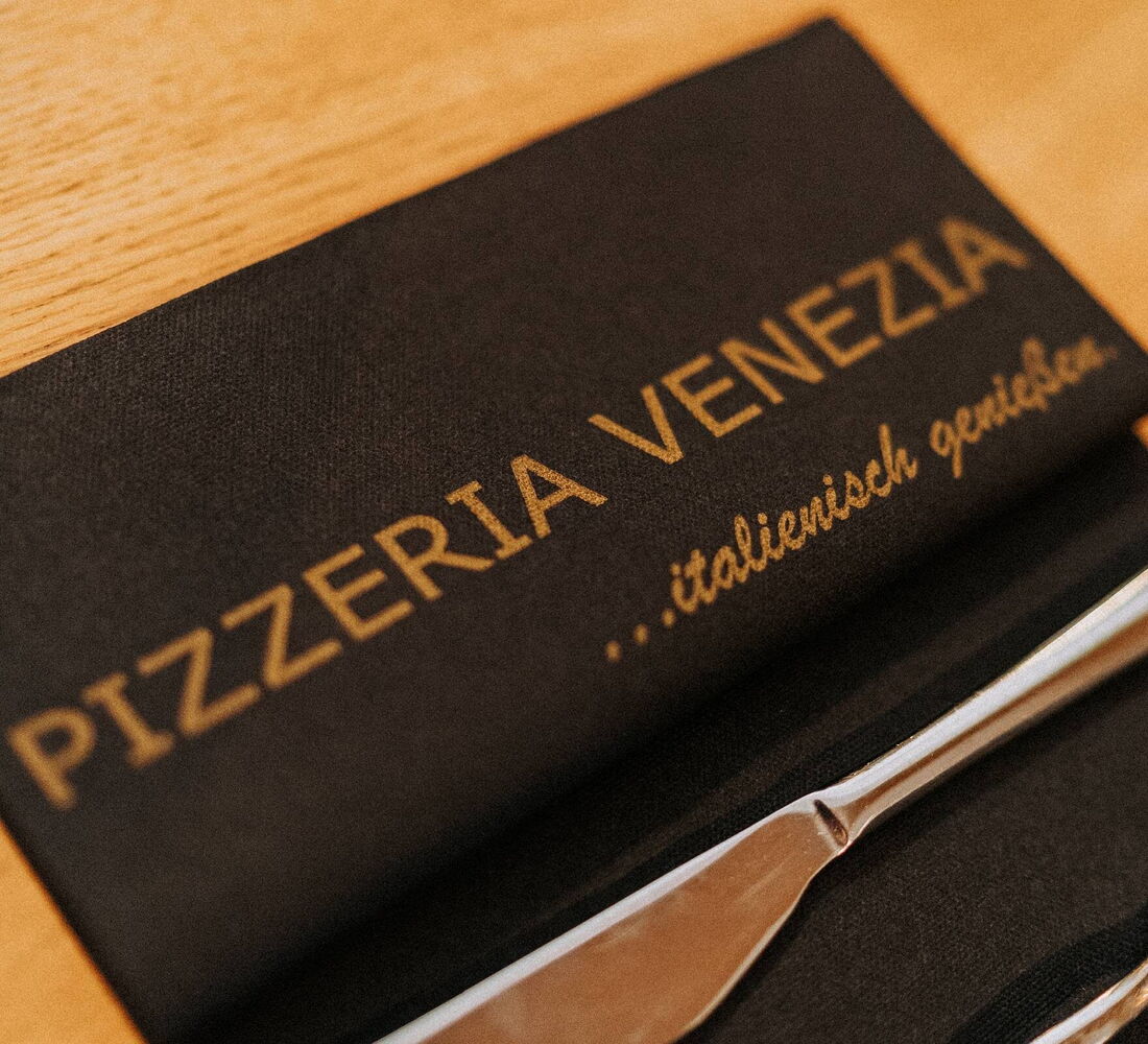 Serviette mit dem Schriftzug Pizzeria Venezia – italienisch genießen